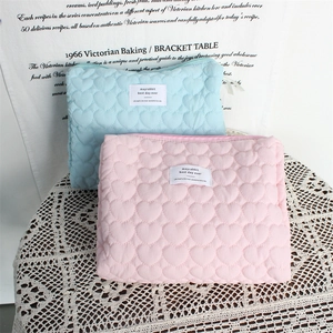 Quilted heart pattern makeup bag in pink and blue on vintage white lace tablecloth