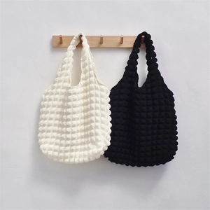 Detail showing the bubble popcorn texture of black and white fabric tote bags