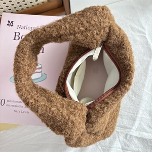Internal view of brown plush teddy handbag showing storage capacity with a smartphone