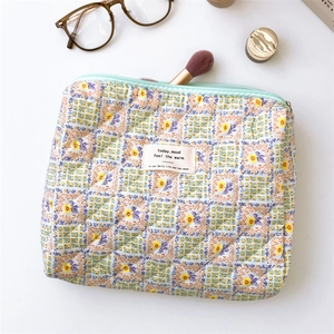 Detailed close-up of quilted floral cosmetic bag showing soft cotton texture and zipper