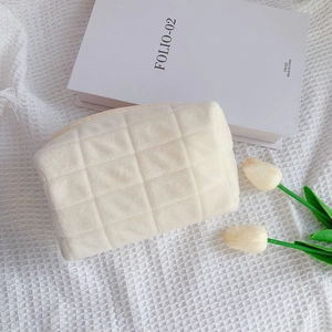 Quilted cream fleece cosmetic bag with grid pattern and soft texture for makeup storage