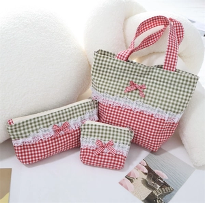 Detailed set of three red and green plaid storage bags with lace trim and bows