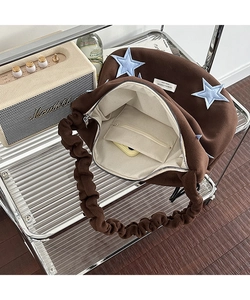 Detail of brown fleece tote bag with blue star patch and pleated adjustable shoulder strap