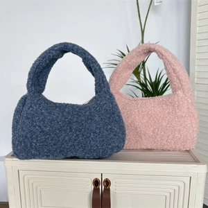 Detail of pink and blue plush handbags featuring soft faux shearling texture and zipper