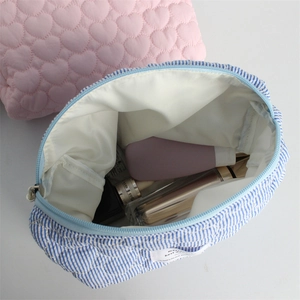 Close-up of quilted cotton cosmetic bag interior with zipper and pink heart pattern