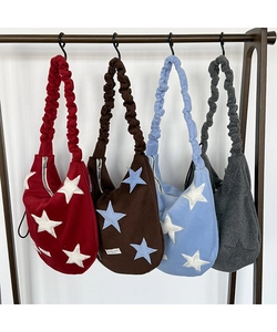 Detail of star-patterned wool shoulder bags with ruched straps in four various colors