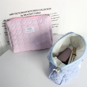Quilted heart cosmetic bags in pink and blue featuring stripe texture and zipper closure