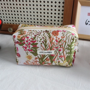 Detail of floral jacquard pencil case featuring May Rabbit label and metallic ring zipper