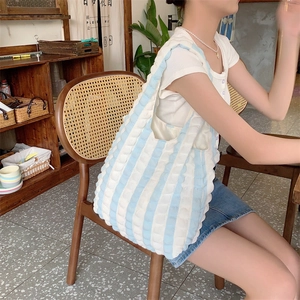 Detail of blue and white striped bubble texture fabric on a casual shoulder tote bag