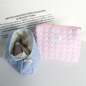 Close-up of quilted heart makeup bag and striped toiletry organizer with zippers