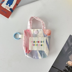Détail de la pochette pour écouteurs à motif tulipes et écusson brodé en tissu doux