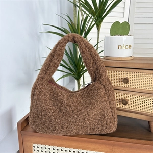 Detail of a brown plush tote bag with a soft texture placed on vintage wooden furniture