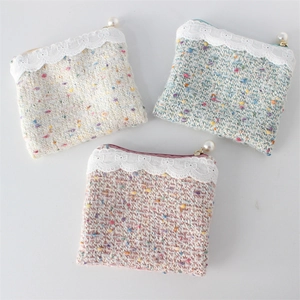 Detail of tweed coin purses with lace floral embroidery and large faux pearl pendants