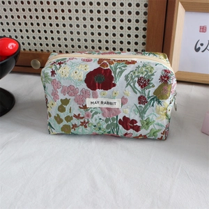 Detail of vintage floral jacquard fabric texture on a large capacity makeup storage bag