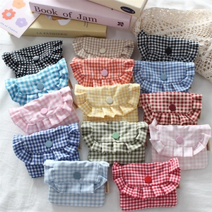 Flat lay of colorful checkered mini pouches with ruffled edges and button closures
