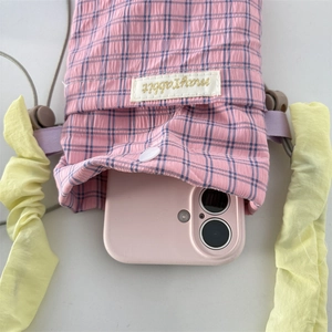 Pink checkered phone storage bag with yellow pleated strap and snap closure detail