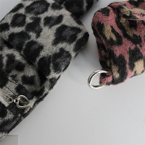 Macro shot of plush leopard print pouches with heart zippers and metal snap rings