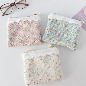 Detail of tweed coin purses with lace trim, pearl zipper pull, and woven texture