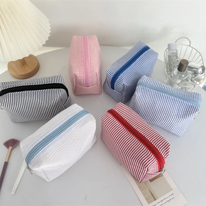 Striped seersucker cosmetic bags in multiple colors with high capacity metal zipper closure