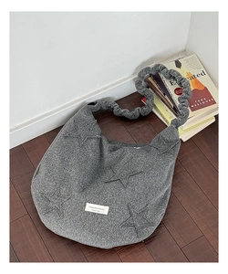 Macro shot of grey hobo bag with star patches and stylish ruched adjustable shoulder strap