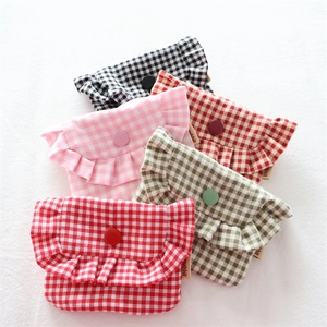 Detailed view of mini checkered cotton pouches with ruffle edges and snap buttons