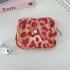 Detailed view of corduroy wallet with pink leopard print and button pocket closure