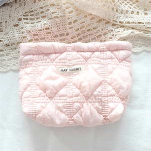 Close-up of pink quilted cosmetic bag featuring a May Rabbit label on fabric