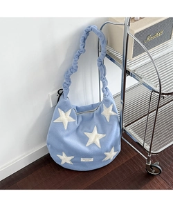 Detail of light blue fuzzy shoulder bag with white stars and cloud-like pleated strap