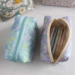 Macro detail of embossed jacquard fabric textures on three aesthetic large-capacity pouches