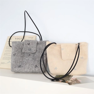 Detail showing embroidered bow patterns and snap closure on canvas tote shoulder bags