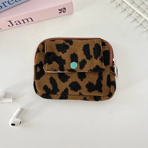 Close-up of leopard print corduroy pouch with a green button flap and metal zipper pull