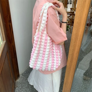 Detail of pink and white striped bubble texture fabric on a cloud-style shoulder bag