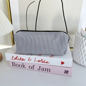 Detailed close-up of blue striped seersucker pencil case with sturdy black zipper