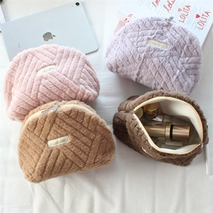 Detail of plush quilted cosmetic bag showing interior storage and gold zipper closure