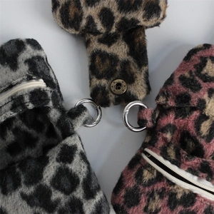 Detailed view of leopard print plush coin purses in grey, brown and pink with silver hooks