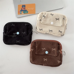 Detail of corduroy coin purses in three colors with bow print and snap button pocket