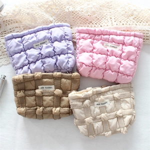 Quilted floral cosmetic bags in four colors with textured patterns and bow accents