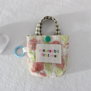 Détail de la pochette florale avec motif tulipes, lapin et crochet de suspension bleu