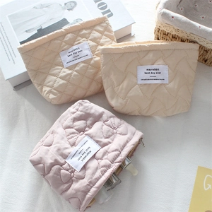 Detail of quilted cotton makeup bags with bow patterns and internal storage capacity