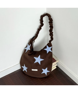 Detail of star patchwork on brown wool tote bag with ruched adjustable shoulder strap