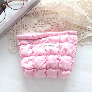 Pink quilted lipstick bag featuring May Rabbit label and elegant lace backdrop