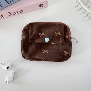 Detail of corduroy pouch with bow pattern showing the front pocket and metal zipper