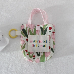 Détail de la mini pochette à motif tulipes avec sangle rose et boucle de suspension