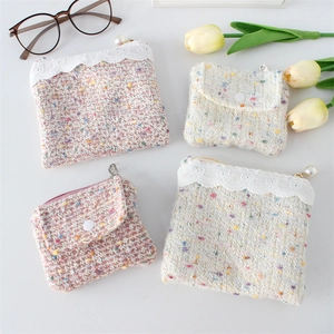 Detailed view of tweed coin purses with lace trim, pearl zippers and snap buttons