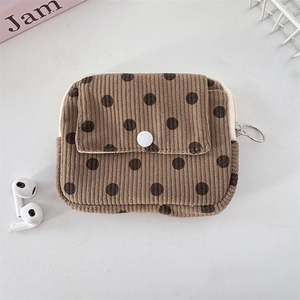 Macro detail of brown corduroy polka dot wallet with snap button and zipper closure