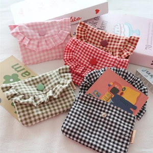 Close-up of checkered fabric mini pouches with ruffle details and snap buttons