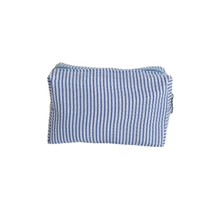 Blue and white seersucker striped toiletry bag with zipper closure for storage