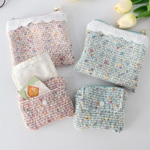 Close-up of tweed coin purses with pearl zippers, lace trim, and soft pastel textures