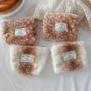 Plush deer pattern makeup pouches with May Rabbit label in a cozy flat lay setting