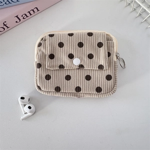 Detailed view of corduroy coin purse with dark polka dots and snap button closure